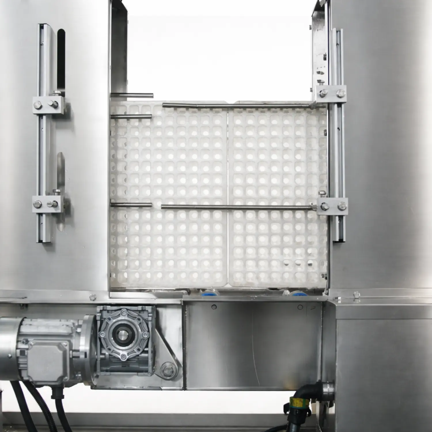 Close-up view of a tray washer cleaning seedling trays inside a stainless steel washing chamber